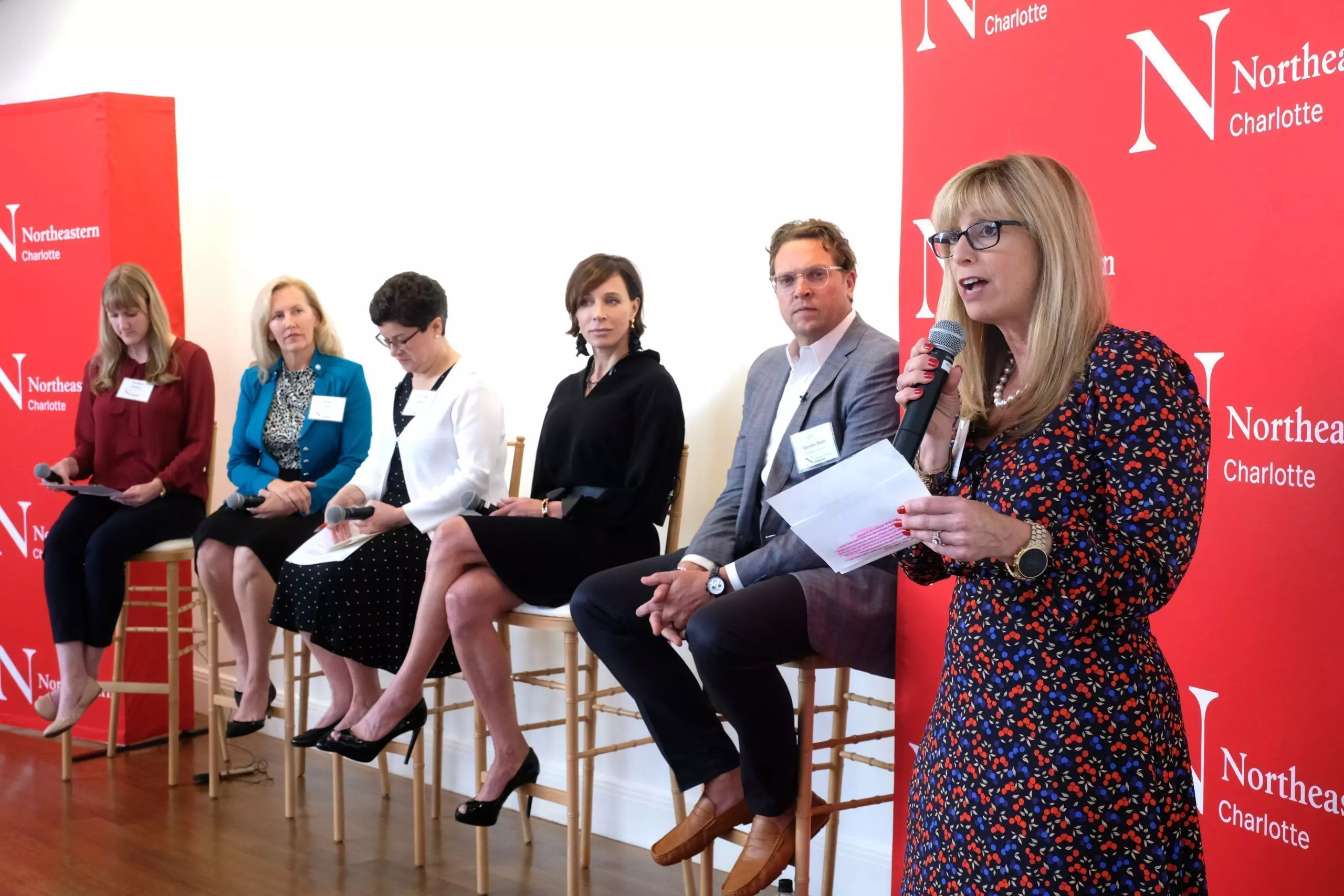 The panel and audience. The panel from left: Caroline Hudson, Charlotte Business Journal, Moderator; Becky Fox, MSN, RN-BC, Vice President, Chief Information Officer, Atrium Health; Carmen Sceppa, MD, PHD, FGSA. Dean, Bouve College of Health Sciences, Northeastern University; Paula Kranz, MPSA, Executive Director, Novant Health Innovation Lab; Mike Vander Baan, MBA, Chief Strategy Officer, StarMed Healthcare. Angela Hoskins, MBA, MSN, RN. CEO and Dean, Northeastern University-Charlotte.